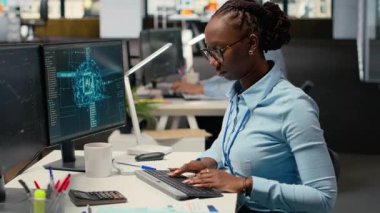 Ofisteki tüccar, analitik çizelgeleri yorumlamak, alım ve satımı optimize etmek için yapay zeka teknolojisini bilgisayar üzerinde kullanıyor. Afrikalı Amerikalı kadın kazancı maksimuma çıkarmak için derin öğrenme otomatikleştirmesi kullanıyor, kamera B