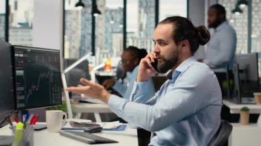 Yatırım danışmanı müşteriyle telefonda konuşuyor, portföy performansını gözden geçiriyor. Tüccar müşteriyle telefon görüşmesi yapmak için akıllı telefonu kullanıyor, mali strateji sağlıyor, kamera B