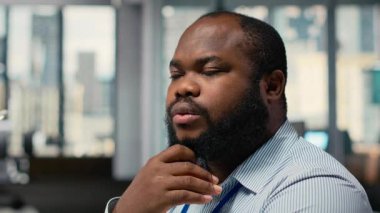 Borsa analizlerini inceleyen, düşünme, malzeme firması ofisindeki ticaret stratejilerini değerlendiren tüccarlara yakın olmak. Afrika kökenli Amerikalı adam beyin fırtınası yapıyor, finans piyasalarında risk değerlendirmesi yapıyor, kamera B