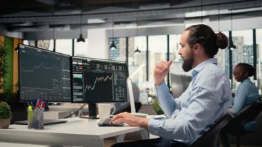 Ofisteki Mutlu Portföy Müdürü, borsa yatırımlarının olumlu dönüşünü kutluyor. Neşeli tüccar performans ölçümlerinden memnun, yatırım fırsatını tanımladıktan sonra heyecanlanan, kamera A