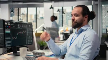 Yatırım yapmadan önce beyin fırtınası yapan, gülümseyen, seçimine güvenen bir tüccar. Komisyoncu şirket uzmanı ticaretten önce düşünüyor, kendine güvenini gösteriyor, kamera A