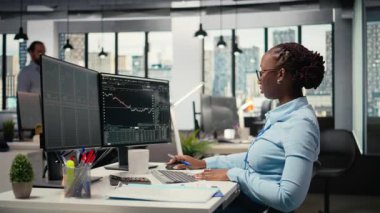 Aksesuar şirketinin sermaye analisti üç aylık kazançları değerlendirip gelecekteki hisse senedi değerini belirlemek için not alıyor. Tüccar yatırımları geliştirmek, bilgi yazmak, kamera A için finansal analiz yürütüyor.