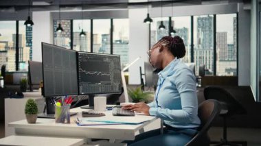 Ofisteki öz sermaye analisti üç aylık kazanç belgelerini gözden geçirip gelecekteki borsa değerini belirlemek için telefonda konuşuyor. Tüccar görüşmeler yapıyor, yatırımları geliştirmek için finansal analiz yapıyor, kamera A