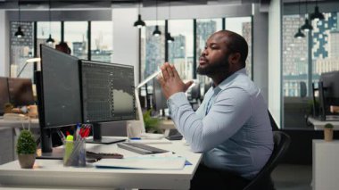 Ofisteki portföy yöneticisi sermaye tahsisini istatistik ve ekonomik göstergelere göre değerlendiriyor. Prop firması uzmanı iş büyümesini hızlandırmak için ekrandaki araştırma raporlarını inceliyor, kamera A