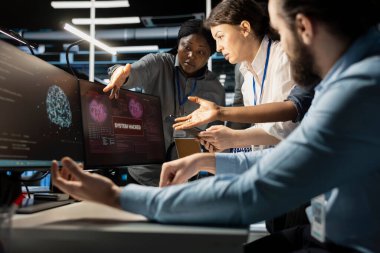 Yapay zeka veri merkezindeki programcılar virüs alarmına tepki göstererek kritik sistemleri korumak için protokolü başlatıyorlar. Sunucu odası bilişim uzmanları beyin fırtınası yapıyor, hacker saldırısından sonra tehlikeli ekipmanları değerlendiriyor.