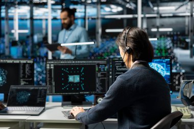 Veri merkezindeki yönetici mikrofon ile konuşuyor, sorun giderme teçhizat bağlantı sorunları yapay zeka kullanılarak. Bilgi işlem uzmanı sunucu merkezinde teknik destek yapıyor, uzaktan arıyor, güvenlik sistemleri denetliyor