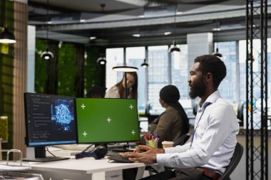 Kodlamak için yeşil ekran PC kullanan teknisyen, hataları en aza indirmek için yapay zeka uygulamalarını test ediyor, sistem istikrarını geliştiriyor. Krom anahtar bilgisayar kullanarak performansı optimize eden teknoloji başlangıç ofisi uzmanı