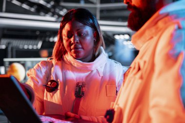 Yörünge teknisyenleri kırmızı ışıkta sorun çıkarıyorlar. Uzay gemisi mühendisleri, işlemleri etkileyen hasarlı donanım elektroniklerini tamir etmek için dizüstü bilgisayar kullanıyor.