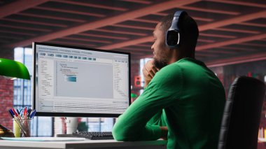 Modern bir programlama dilinde kod yazan serbest geliştirici. Genç adam ana ofiste ikili kod kullanırken büyük verileri, algoritmaları ve performansı optimize ediyor. Kamera A.