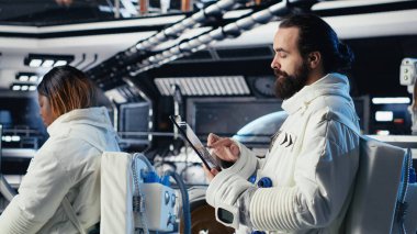 Gelişmiş teknoloji uzay aracındaki astronot ekibi rutin görev kontrolü sırasında Kırmızı Gezegen Özet Analizlerini kontrol ediyor. Takım çalışması Yörünge İstasyonu mürettebatı Mars verilerine bakmak için aygıt kullanıyor