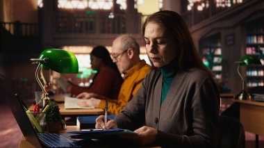 Dizüstü bilgisayarında online akademik materyallerle öğrenim gören son sınıf öğrencisi, sınavlar ve tez tamamlama için önemli bilgiler topluyor. Yaşlı adam üniversiteden mezun olma konusunda ciddi..