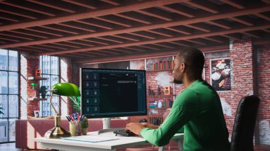 Evdeki siyahi serbest çalışan erkek, görev tamamlama, otomasyon ve makine öğrenimi için yapay zeka sohbet robotu kullanıyor. Genç yetişkinler, suni zeka kullanarak yeni fikirler üretirler. Kamera B.