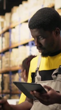 Dikey Video Siyah elemanı raflardaki kutulardaki nakliye etiketlerini işlemek için barkod tarayıcısı kullanıyor. İz sürme bilgisi ve doğru lojistik ile paket izleme servisi için yanlış etiketler taranıyor