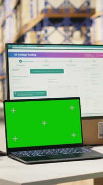 İthalat ihracat detaylarıyla ilgilenen dikey video çalışanı. Ekranda kopyalama alanı var. Depo masasında güvenlik yeleği ve kask takıyor. Personel izleme paketi yazılım takibi. Kamera.