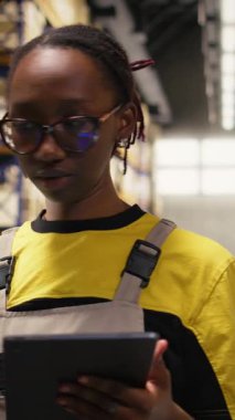 Dikey Görüntü Lojistik Merkezi kadın çalışanı envanter kaydı için havayolu faturalarını tarıyor, tabletteki ithalat ihracat sistemindeki kayıtları güncelliyor. Sanayi deposunda e-ticaret operasyonları