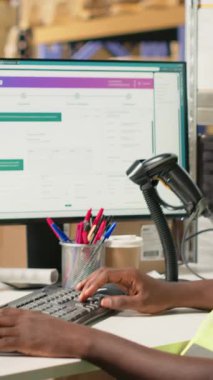 Dikey Video Siyah lojistik işçileri bilgisayar yazılımında kargo takibi yaparak kargo etiketli kutular için ekspres teslimat sağlıyorlar. Sanayi e-ticaret dağıtım operasyonları devrede