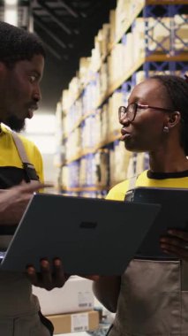 Dikey Video Deposu çalışanları paketleri denetliyor. Cihazların bilgilerini takip ediyor, sevkiyat için kargo hazırlıyor. Depoda dağıtım işlemlerini envanter işleme araçlarıyla yürüten insanlar