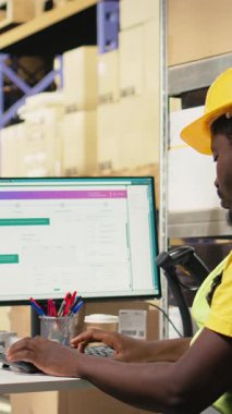 Dağıtım sistemi için takip yazılımlarının envanter verilerini inceleyen dikey video kasiyeri, organize raflarla dolu lojistik merkez depo odası. Çevrimiçi perakende satış ve tedarik zinciri