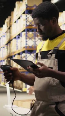 Dikey Video Siyah elemanı raflardaki kutulardaki nakliye etiketlerini işlemek için barkod tarayıcısı kullanıyor. İz sürme bilgisi ve doğru lojistik ile paket izleme servisi için yanlış etiketler taranıyor