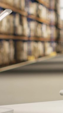 Dikey Afrikalı Amerikalı kadın yelek içinde barkodları tarıyor paket sevkiyatı için, nakliye etiketlerinin takip edilmesini sağlıyor. Dağıtım için kargo bilgilerini doğrulayan miğferi olan kadın