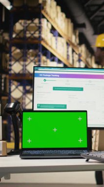 Dikey video depo görevlisi ekrandaki krom anahtarın yanındaki etiketleri kontrol ediyor, endüstriyel depolama raflarıyla depoda çalışıyor. Dağıtım ve e-ticaret ile tatmin merkezi ilgilenir. Kamera.