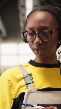 Dikey Video Siyah kadın çalışanları lojistik merkezdeki müşteri hizmetlerine cevap veriyor paketler için sipariş takibi, yanlış adres sorununu çözme ve nakliye detaylarını güncellemede yardımcı oluyor. Yardım hattı