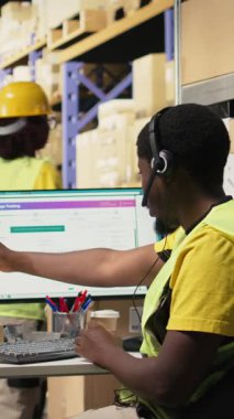 Vertical Video Black çağrı merkezi operatörü sipariş karışıklığı sorunu olan bir müşteriye yardım ediyor, depo tesisinde paket izleme yazılımının paket durumunu doğruluyor. Müşteri hizmetleri bildirim