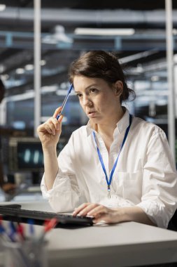 Veri merkezi teknisyeni teçhizatı tamir etmek ve bakım işleri için beyin fırtınası yapıyor. Sunucu çiftlik çalışanı sistem kontrolü yaptıktan sonra ağ donanımlarını nasıl onaracağını düşünüyor