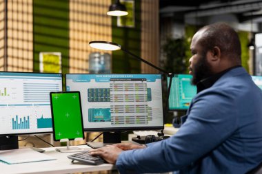 Profesyonel yönetici grafikler ve izole edilmiş bir model ekran üzerinde çalışarak uluslararası piyasada iş başarısı sağlıyor. Ofisteki küresel genişleme stratejisi için veriler gözden geçiriliyor.