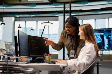 İş yerindeki küçük Dev 'e danışmanlık yapan dost canlısı kıdemli mühendis. Yapay zeka ölçümlerini gözden geçiriyor. Mutlu Afro-Amerikan Yöneticisi intörn rehberlik kod gözden geçirme makine öğrenme kullanarak