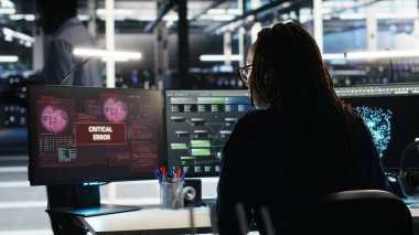 Arızalı veri analizi yapay zeka jeneratöründen endişelenen stresli sunucu merkezi yönetimi. Sistem ölçümlerini gösteren yapay zeka aracındaki kritik hata nedeniyle endişeli veri merkezi çalışanı, kamera B