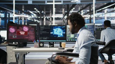 Tekerlekli sandalyedeki çok çalışan adam sunucu merkezi yapay zeka analizlerine bakarken hata uyarısı yapılmasından rahatsız oluyor. Arıza nedeniyle arızalı veri merkezi çalışanı, düğüm ağacı aracı, kamera A