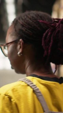 Dikey Afrikalı Amerikalı işçiler iş lojistik sistemi için ürün işliyor, endüstriyel raflarla dolu bir depo alanı. Çevrimiçi perakende satış merkezinde nakliye protokolleri. Kamera.