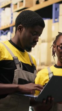 Dikey Video Deposu çalışanları paketleri denetliyor. Cihazların bilgilerini takip ediyor, sevkiyat için kargo hazırlıyor. Depoda dağıtım işlemlerini envanter işleme araçlarıyla yürüten insanlar