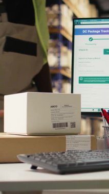 Dikey Afrikalı Amerikalı kadın barkodları kutulardaki sevkiyat detayları için tarıyor, paket izleme yazılımının havayolu faturasını doğru paket güncellemeleri ile kaydediyor. Tarayıcı teknolojisi