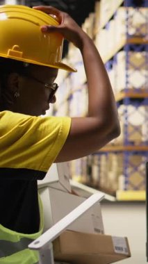 Vertical Video Fulfillment Center personeli müşteriler için rota bilgisi içeren paket izleme yazılımını güncelliyor, ekspres teslimat için e-ticaret siparişlerini denetliyor. Sevkiyat koordinasyonu. Kamera A.