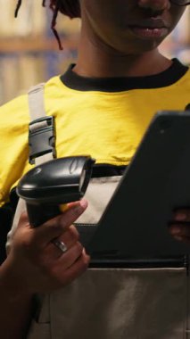 Dikey Video Çalışanı, tamamlama merkezindeki karton kutularda barkod tarayıcısı kullanıyor. Organize raf, paket etiketleri ve güzergah planlaması verimli dağıtım ve sevkiyat desteği. Lojistik Merkezi