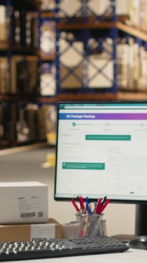 Lojistik merkezde çalışan dikey Afrikalı Amerikalı kadın bilgisayarla ilgili bilgileri takip ediyor, teslimat güzergahını ve diğer sevkiyat detaylarını gerçek zamanlı olarak güncelliyor. Çevrimiçi siparişler için paket durumu takip ediliyor