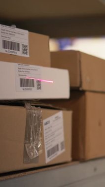 Lojistik personelinin dikey videosu envanter kaydı için havayolu fatura etiketlerini tararken, tabletteki ithalat ihracat sistemindeki kayıtları güncellerken. Sanayi deposunda e-ticaret operasyonları