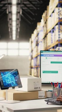 Yapay zeka sanal asistanıyla envanter lojistiğini yöneten dikey video depo çalışanı teslimat ve sipariş işlemleri için nakliye etiketlerinin güncellenmesine yardımcı oluyor. Çevrimiçi alışveriş perakende