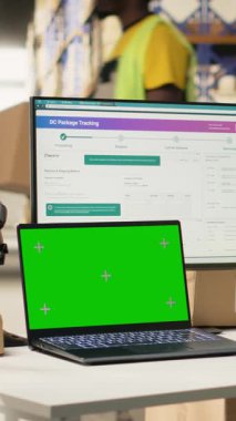 Dikey video depo görevlisi ekrandaki krom anahtarın yanındaki etiketleri kontrol ediyor, endüstriyel depolama raflarıyla depoda çalışıyor. Dağıtım ve e-ticaret ile tatmin merkezi ilgilenir. Kamera.