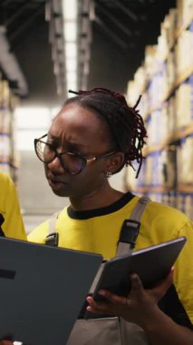 Vertical Video Large iş depo personeli dizüstü bilgisayar verileri, dağıtım prosedürleri ve depolama merkezi rafları etrafında depolama işlemleri ile sipariş gerçekleştirme işlemleri yürütüyor. Paket Sıralama