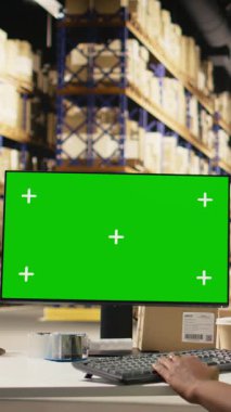 Dikey Videolu Kadın çalışanı, dağıtım işlemleri için büyük askıları olan endüstriyel depoda çelik yelek giyerek fotokopi masasının yanındaki kutuların üzerindeki hava yolu fatura etiketlerini doğruluyor. İnternetten alışveriş