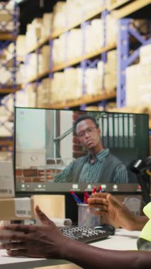 Dik Video Deposu katibi, internet üzerinden müdürle görüntülü görüşme yapıyor. Dağıtımdan önce sipariş sevkiyatının detaylarını iletiyor. Zenci adam ve CEO uzaktan video konferansında.