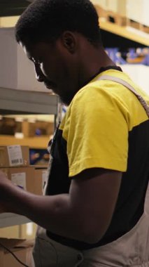 Dikey Video Çalışanı, tamamlama merkezindeki karton kutularda barkod tarayıcısı kullanıyor. Organize raf, paket etiketleri ve güzergah planlama destek dağıtımı ve sevkiyatı. Lojistik merkezi. Kamera A