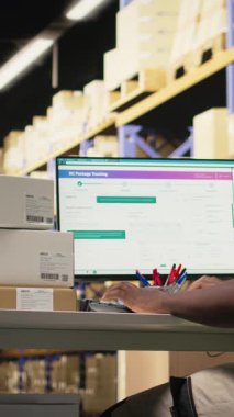 Dikey Video Deposu çalışanı havayolu fatura etiketlerinin takip bilgileriyle siparişleri kaydediyor, e-ticaret perakende sanayii için ithalat operasyonlarını güvence altına alıyor. Adam sıra gereğince çalışır. Kamera A.