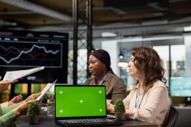 Güçlenmiş iş kadınlarından oluşan bir grup modern ofis ortamında dizüstü bilgisayar ekranında çalışarak kurumsal feminizm zihniyetini ve büyüme vizyonunu somutlaştırıyor. Güçlendirme.