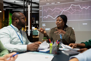 Siyahi büro yöneticisi, iş başarısı sağlamak için bölümler arasındaki işbirliğini araştırıyor ve çalışanlarla çalışma saatleri dışında mevcut girişimcilik hedefleri belirliyor. Hava tahminleri ortakları.