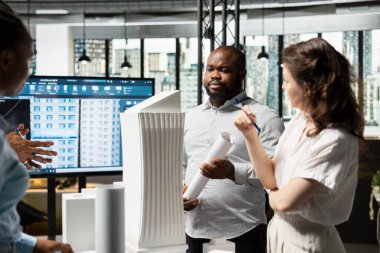 Emlak müteahhitleri, kentsel planlama sürecinde altyapı ihtiyaçları ve tasarım yeniliği olan konut projeleri stratejisi üzerinde 3D modellerle imar düzenlemelerini incelemektedir..