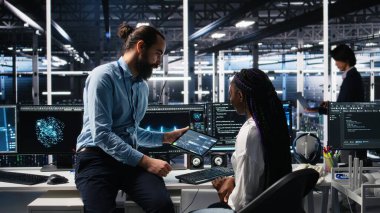 Sistem yöneticisi ve veri merkezi çalışanı üretici yapay zekayla kodlama yapıyor. Ekip lideri ve bilişim işçisi sunucu merkezinde yapay zeka kullanan büyük dil model teknolojisi, kamera A